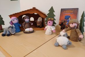 Weihnachtskrippe mit Maria, Josef, einem Engel dem Jesuskind in einer Krippe und Hirten mit Schafen